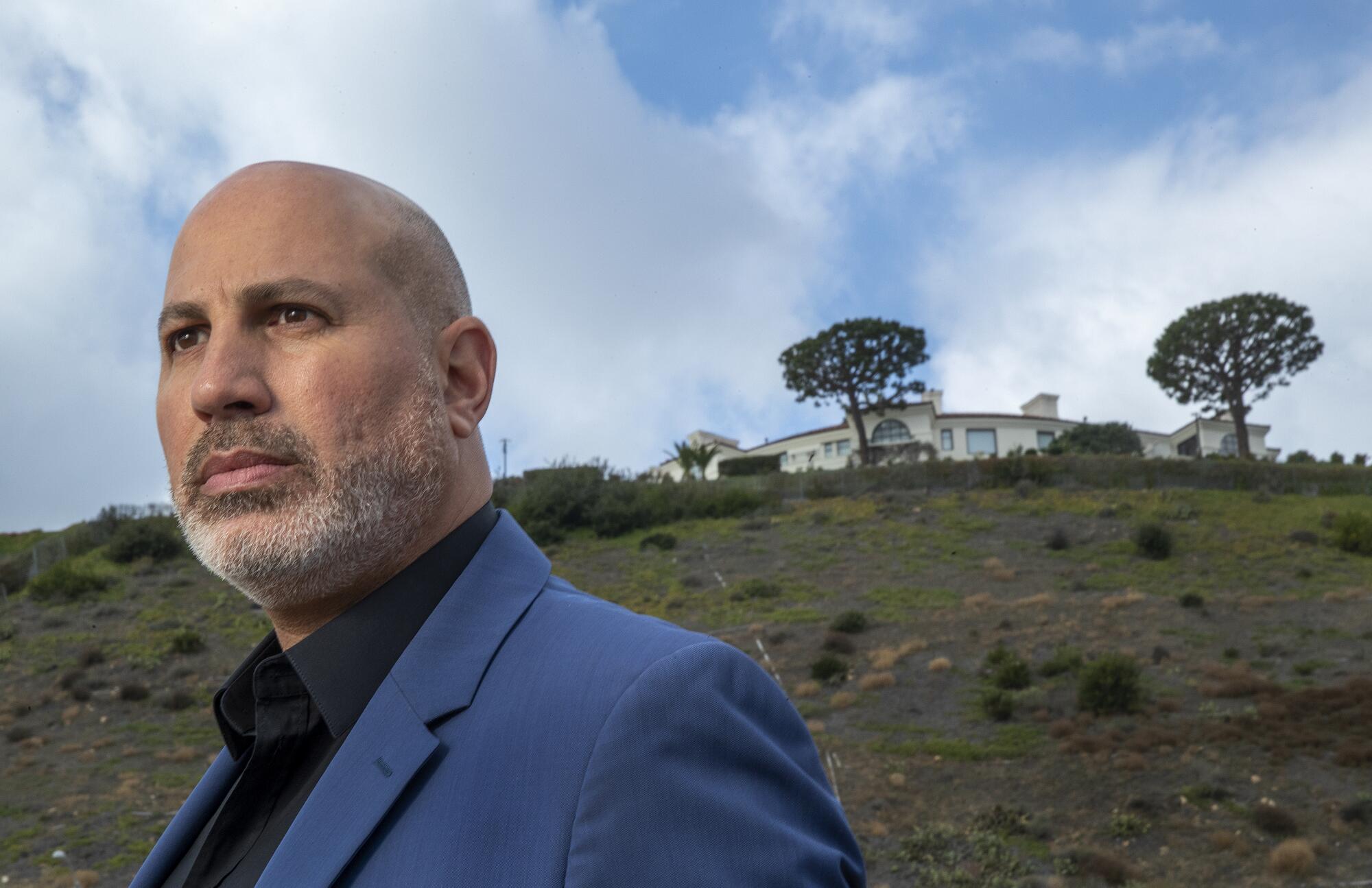 Sam Hakim is suing over the sale of the Malibu mansion seen in the background.