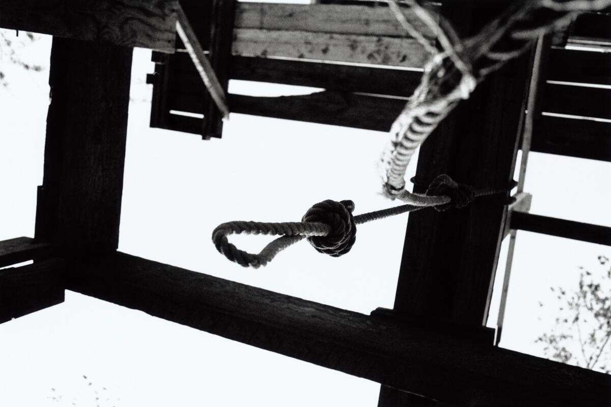 A hanging noose above trap door in gallows, low angle view.