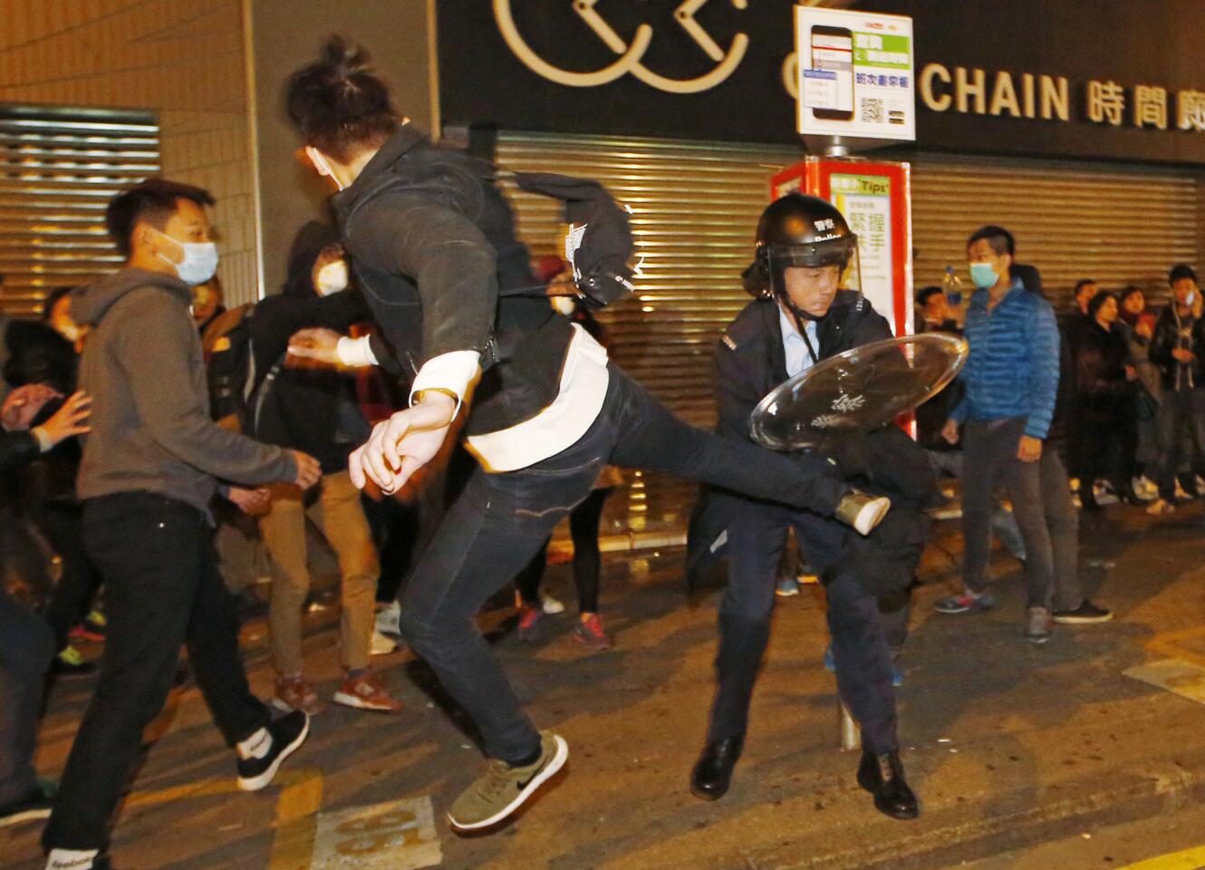 A protester kicks a riot police in Mong Kok district of Hong Kong, Tuesday, Feb. 9, 2016.