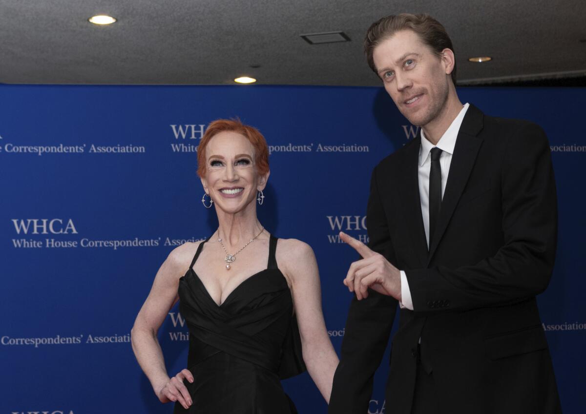  Kathy Griffin poses and smiles in a black gown while Randy Bick holds her hand and points with his index finger