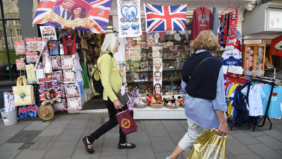 Tourists walk past a shop selling royal souvenirs opposite Windsor Castle.