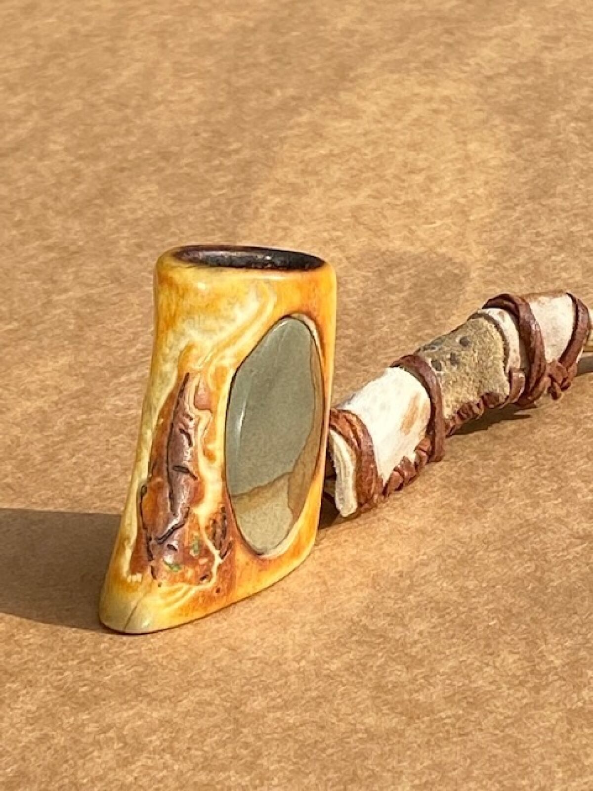 A pipe with a porthole window in its carved bowl.