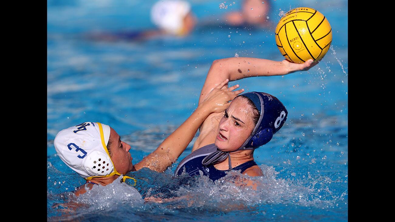 Flintridge Prep girls water polo player #8 Natalie Kaplanyan, left, takes a shot on goal under pressure from #3 Alyssa Conrique during CIF SS Div. VII wild-card match vs. La Mirada High School, at Pasadena Poly in Pasadena on Wednesday, Feb. 14, 2018.