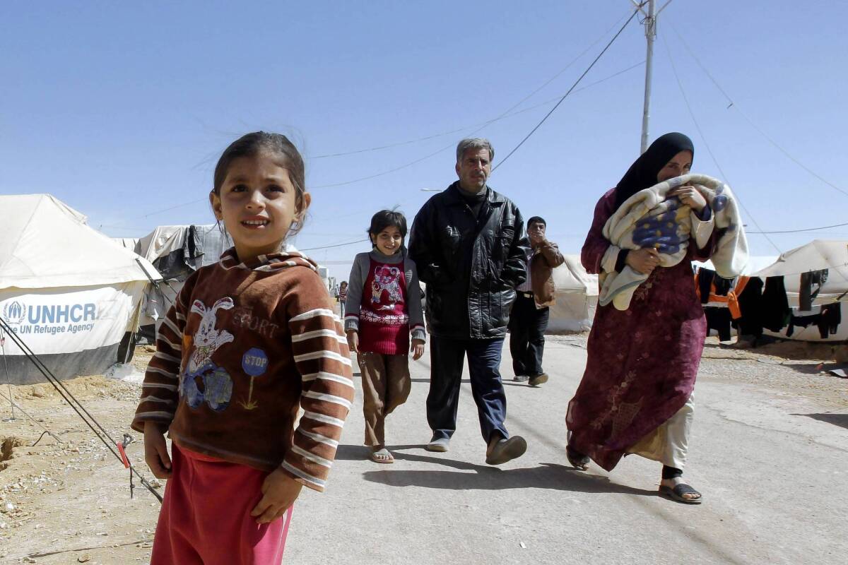 A Syrian family makes its way at the Zaatari refugee camp in Jordan. Initially created to shelter 50,000 refugees, the tent city is now home to about 108,000.