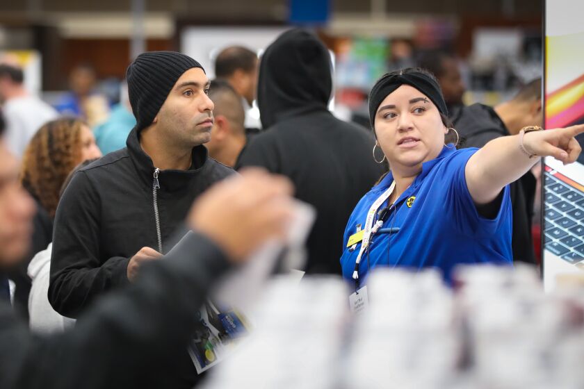 Farzan Fozouni, left, gets directions from Mission Valley Best Buy store employee Jess Montes, right, on Black Friday, November 29, 2019 in San Diego, California.