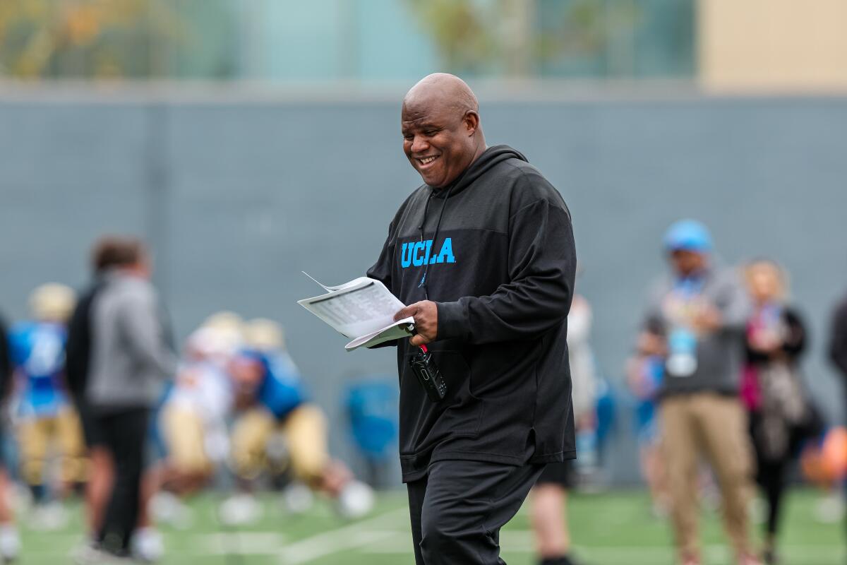 UCLA associate head coach and offensive coordinator Eric Bieniemy smiles during spring practice.