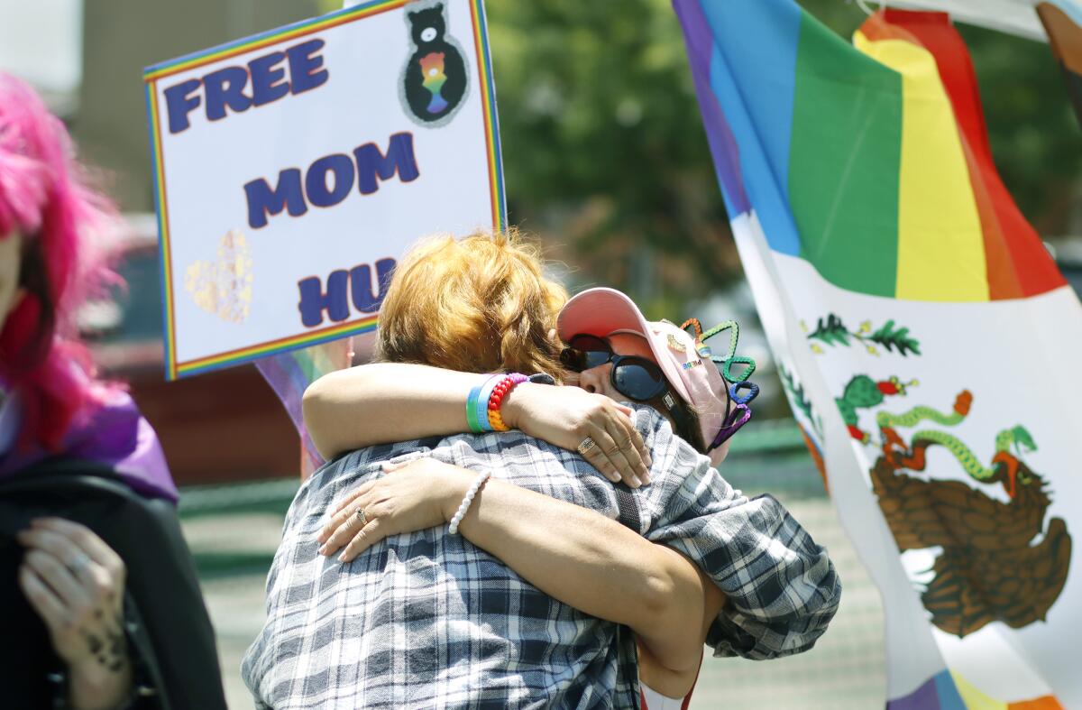 Elisa Scholes hugs a woman at She Fest on Saturday afternoon at the Free Mom Hugs booth