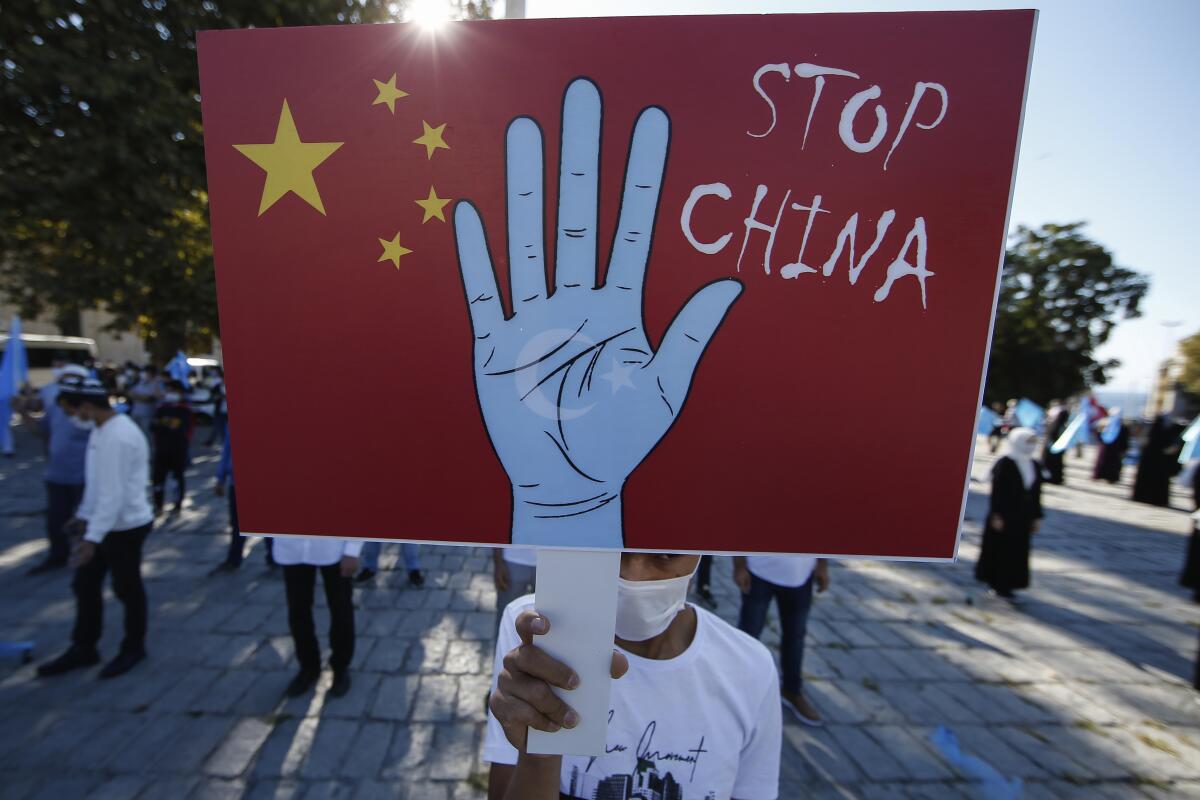  un manifestante de la comunidad uigur en Turquía sostiene una pancarta contra China 