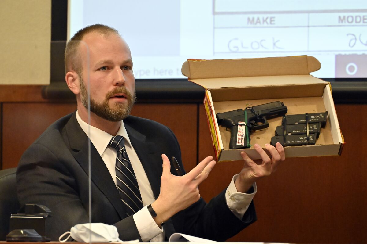 Louisville Metro Police Officer Matt Gelhausen holds up the evidence box contains the firearm used by Brett Hankison during prosecution's questioning Tuesday, March 1, 2022, in Louisville, Ky. Hankison is currently on trial, charged with wanton endangerment for shooting through Breonna Taylor's apartment into the home of her neighbors during botched police raid that killed Taylor. (AP Photo/Timothy D. Easley, Pool)