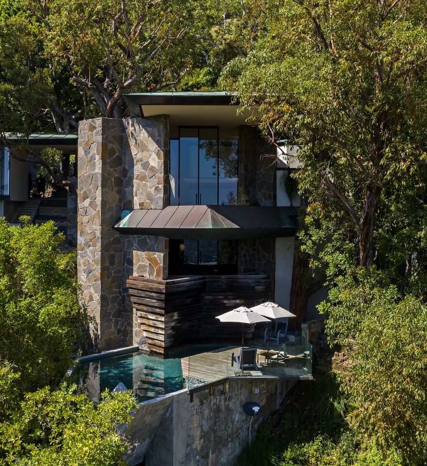 Outside, the roughly quarter-acre property has a balcony that overlooks decking and a cantilevered swimming pool. A carport sits off the front.