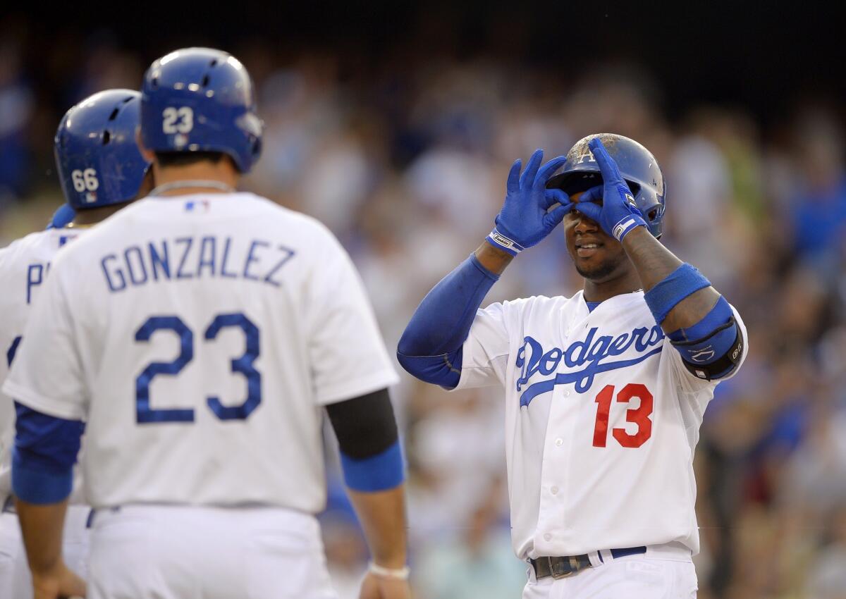 Dodgers shortstop Hanley Ramirez, right, gestures to teammates Yasiel Puig, left, and Adrian Gonzalez after hitting a three-run home run during the first inning of Saturday's 4-3 victory over the Philadelphia Phillies.
