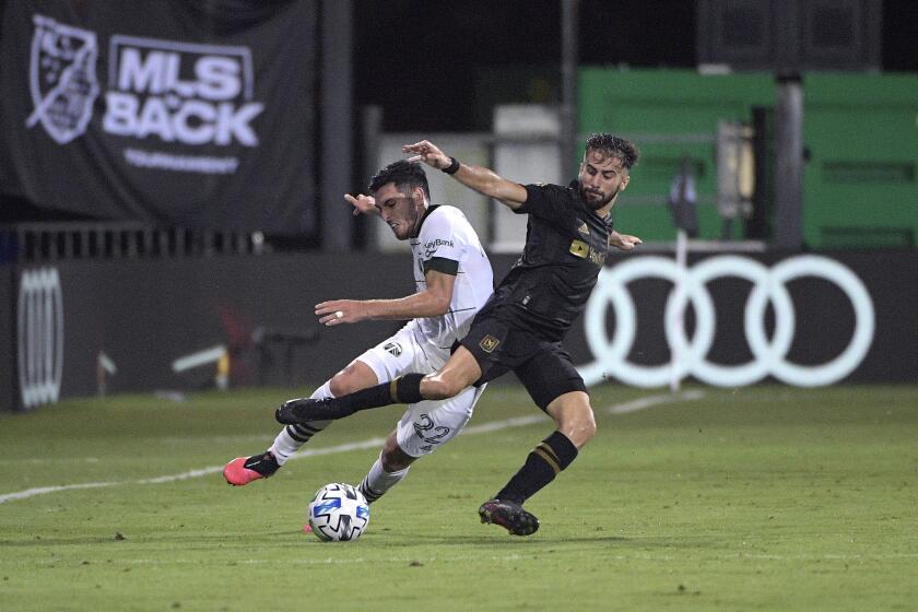 LAFC forward Diego Rossi, right, battles for the ball with Portland Timbers midfielder Cristhian Paredes