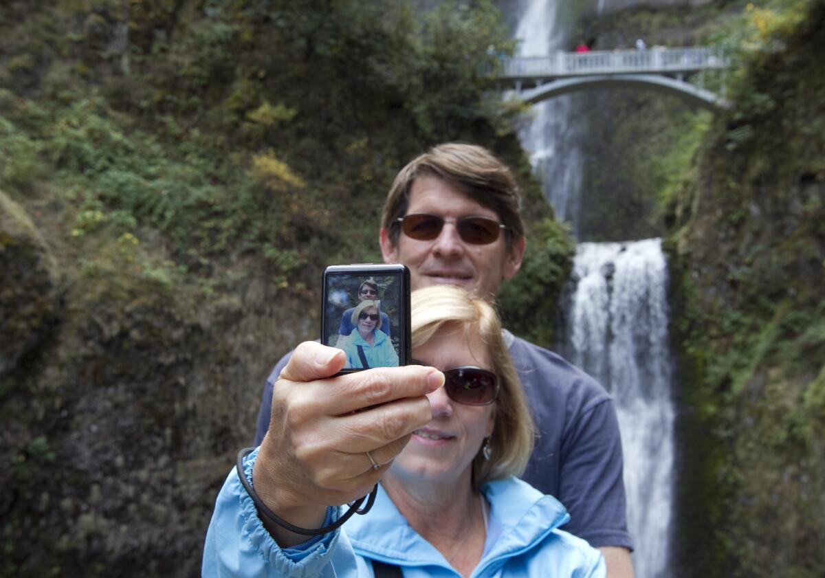 Southern Californians Randy and Lori Frith take a selfie at the Multnomah Waterfalls in the Columbia River Gorge National Scenic Area. Would they have to get a permit under proposed Forest Service regulations?