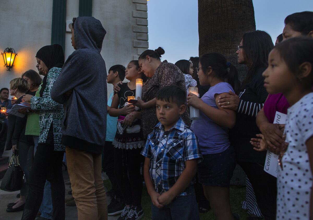 Residents hold a prayer vigil outside Our Lady of Assumption Catholic Church for the victims in the shooting at North Park Elementary School in San Bernardino.