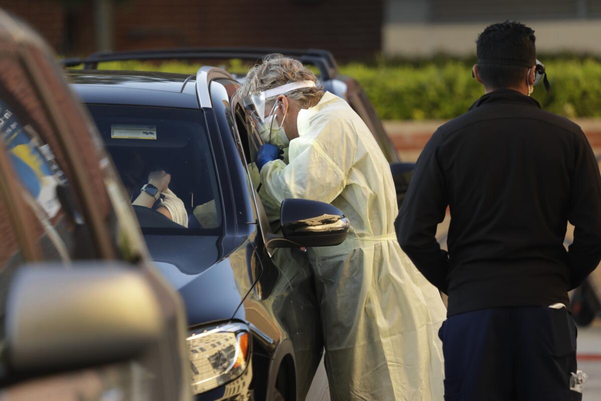 Dr. Mark V. Morocco talks to a woman through her car window at Ronald Reagan UCLA Medical Center.