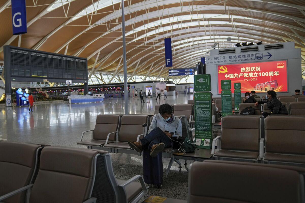 Passengers wait at Pudong International Airport terminal