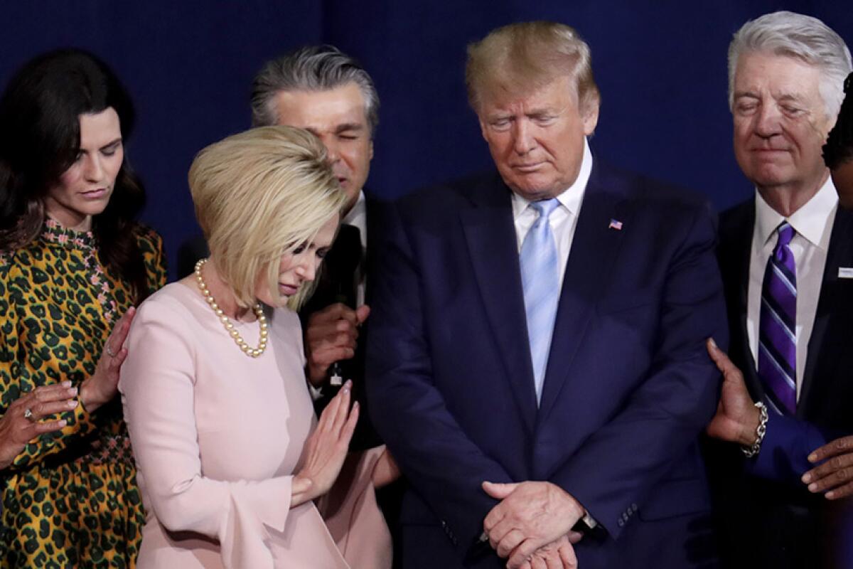 Then-President Trump prays with evangelical faith leaders in 2020. 