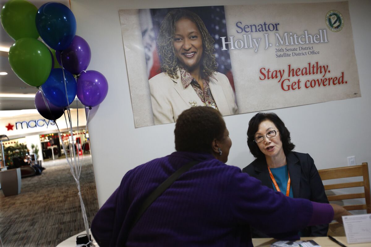 Helen Lee, right, an enrollment counselor, signs up a client for health coverage at a Covered California health insurance exchange office in Los Angeles.