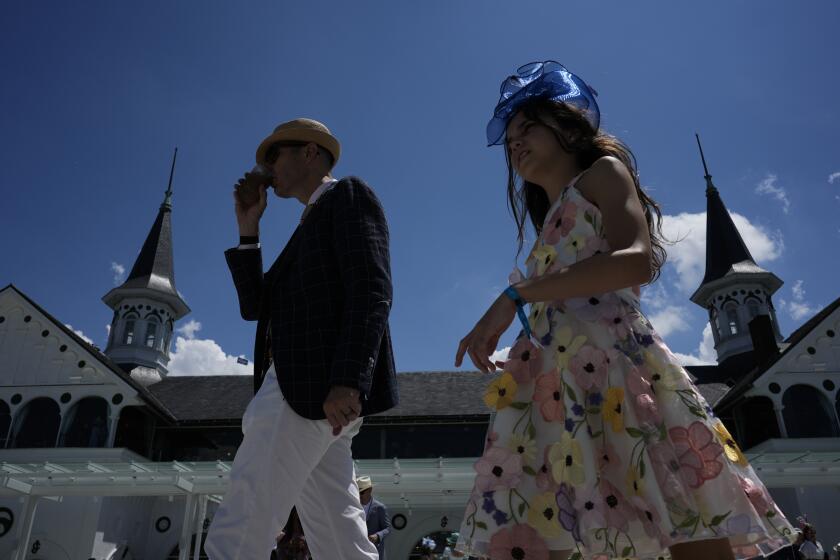 Race fans walk though the grounds of Churchill Downs before the 150th running of the Kentucky Derby horse race Saturday, May 4, 2024, in Louisville, Ky. (AP Photo/Charlie Riedel)
