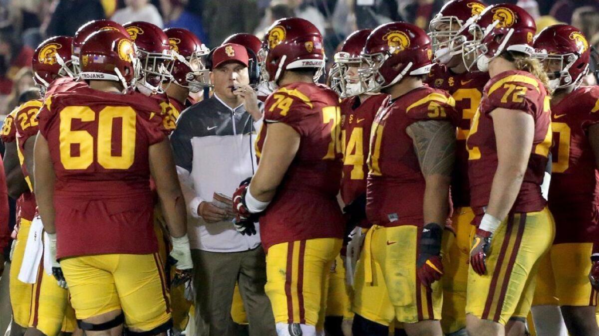USC Coach Clay Helton huddles with his team during the fourth quarter of a game against UCLA at the Rose Bowl on Nov. 19.
