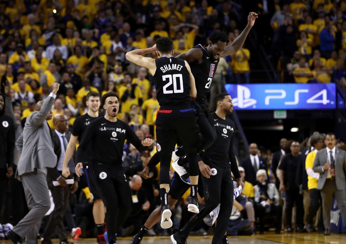 Landry Shamet #20 of the LA Clippers is congratulated by Patrick Beverley #21 after he made a basket to put the Clippers ahead of the Golden State Warriors in the final minute during Game Two of the first round of the 2019 NBA Western Conference Playoffs at ORACLE Arena on April 15, 2019 in Oakland, California.