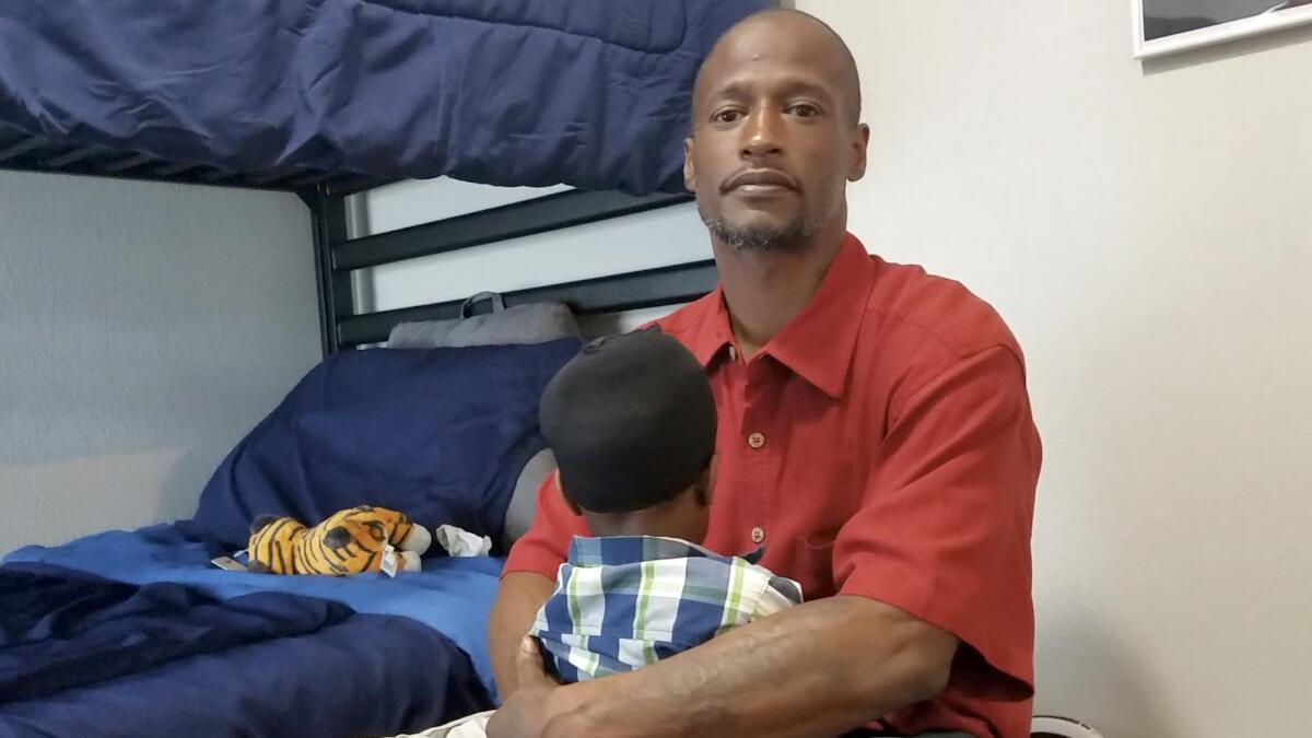Joshua Miller acuna a su hijo de dos años, Jordan, en el refugio Family Place de Dallas, uno de los primeros refugios de violencia doméstica en el país para hombres (Jenny Jarvie / para The Times).