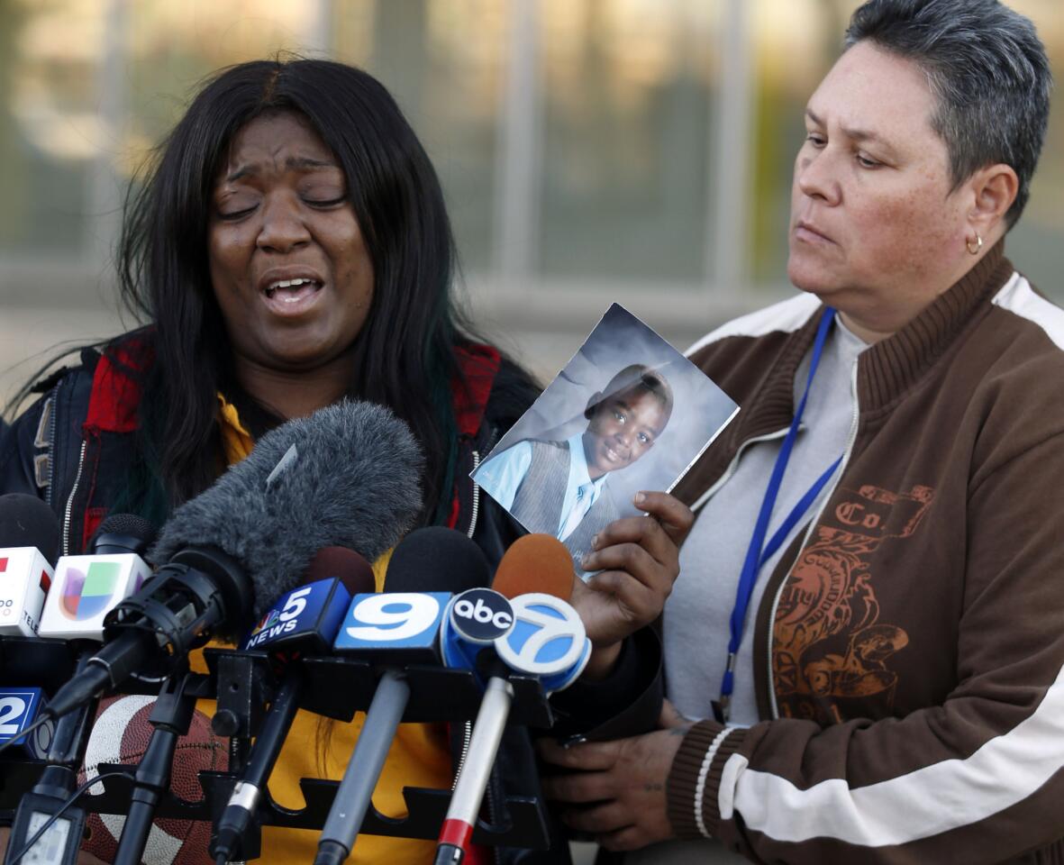 Karla Lee, left, speaks Nov. 3, 2015, at Chicago Police District Area 5 headquarters to ask the public for help in finding the person who shot and killed her 9-year-old son, Tyshawn Lee.