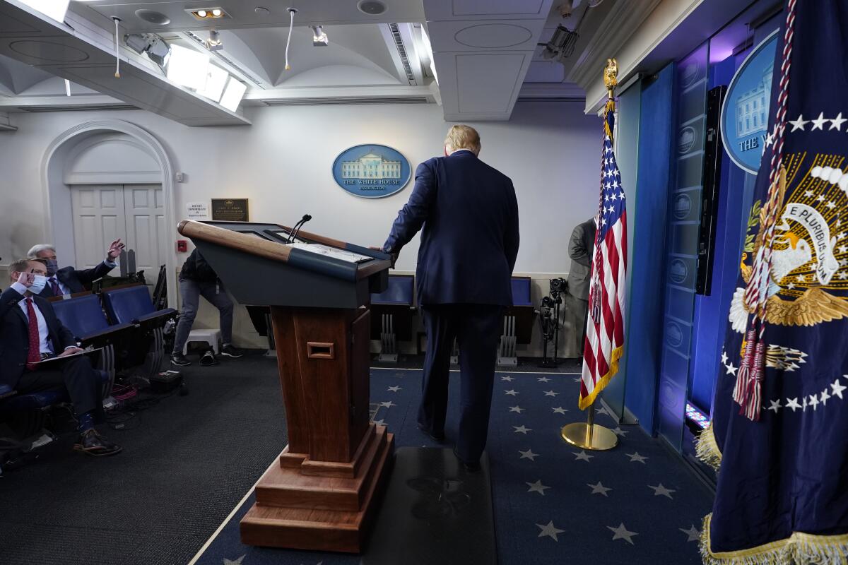 President Trump walks away from the podium in front of reporters in the White House press briefing room