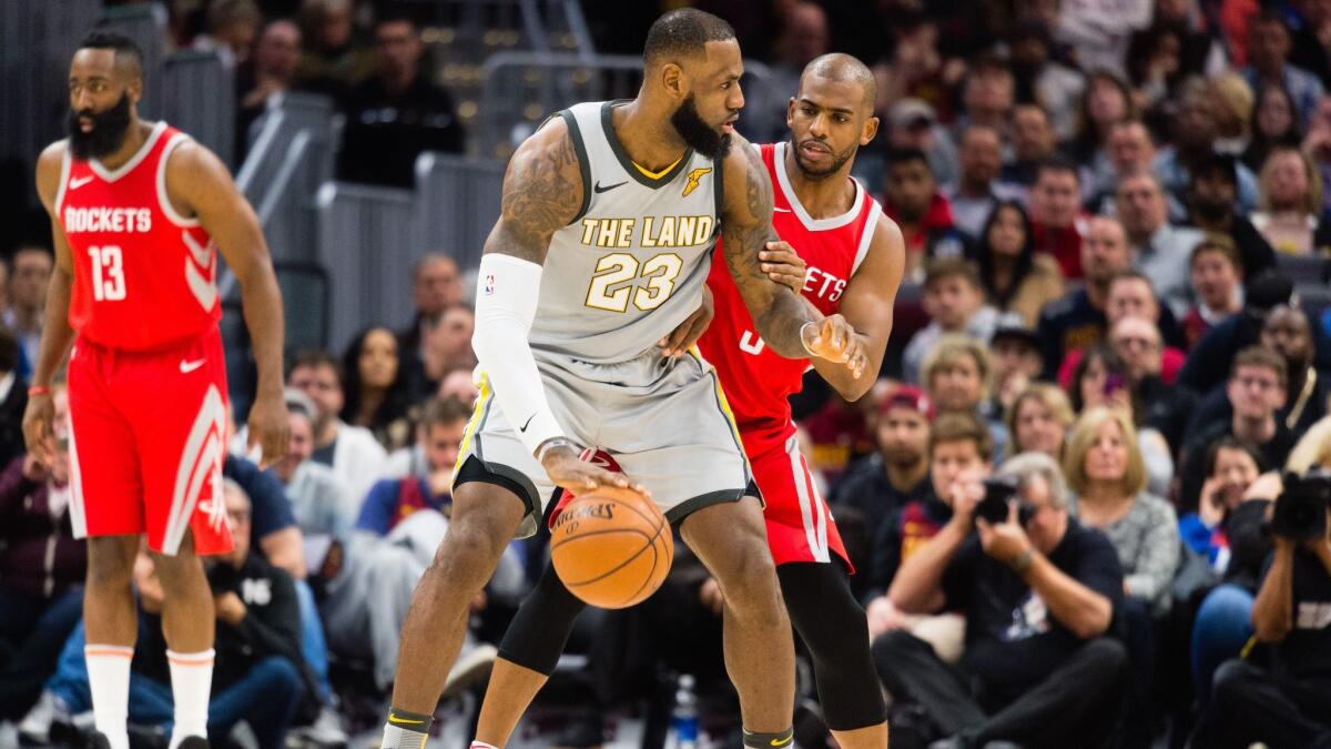 LeBron James tries to drive around Chris Paul during the first half.