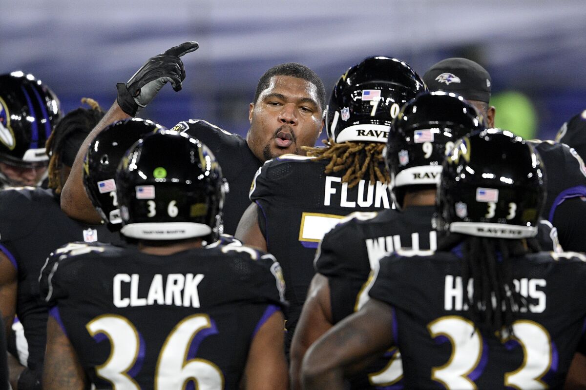 Baltimore Ravens defensive end Calais Campbell, center, leads a huddle with teammates after working out prior to an NFL football game against the Dallas Cowboys, Tuesday, Dec. 8, 2020, in Baltimore. (AP Photo/Nick Wass)