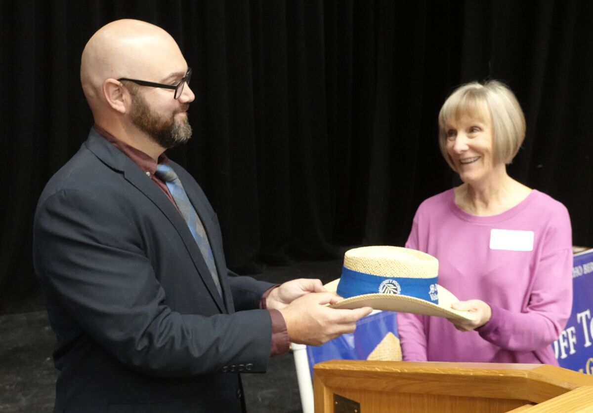 Daniel Wilson, president of the RB Community Foundation, presenting a hat to honoree Mary Olson .