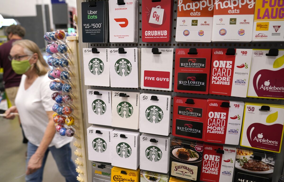 Gift cards for food and beverage businesses sit on display for sale at a retail store in Dallas, Tuesday, Nov. 16, 2021. The holidays have always been defined by disappointing out-of-stock messages on the most popular items. Many shoppers will turn to more to gift cards if they don't like what they see. (AP Photo/LM Otero)