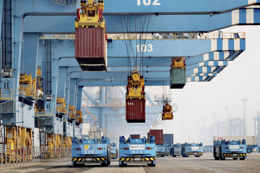 Driverless vehicles move shipping containers at a port in Qingdao in eastern China's Shandong Province, Thursday, Jan. 6, 2022. China's politically volatile global trade surplus surged to $676.4 billion in 2021, likely the highest ever recorded by any country, as exports jumped nearly 30% over a year earlier despite semiconductor shortages that disrupted manufacturing. (Chinatopix via AP)