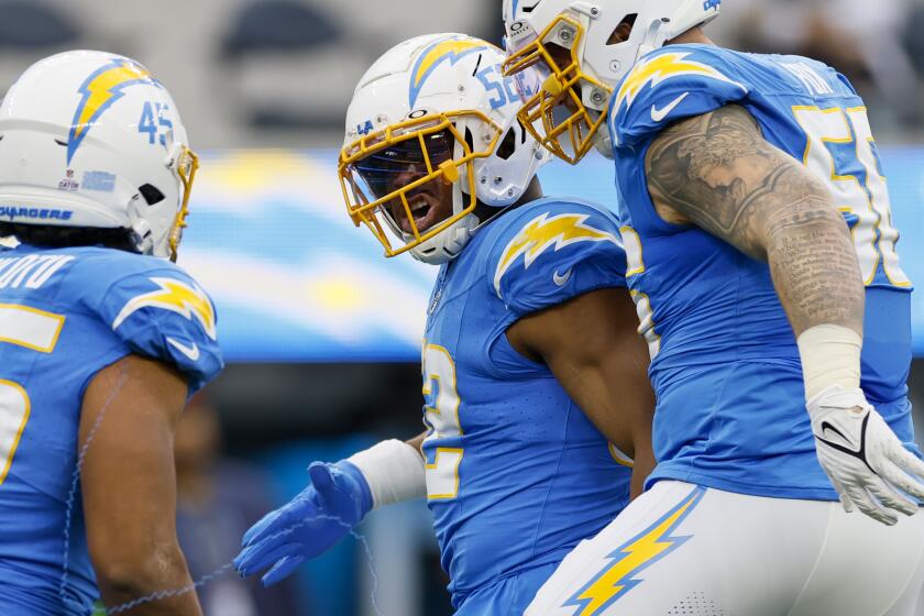 Chargers linebacker Khalil Mack (52) celebrates with teammates after sacking Raiders quarterback Aidan O'Connell.