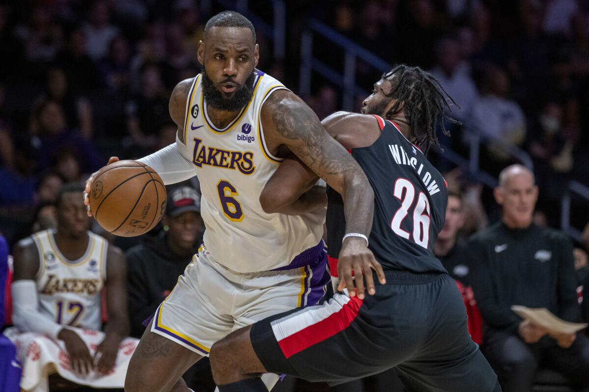Lakers star LeBron James, left, drives around Portland Trail Blazers forward Justise Winslow.