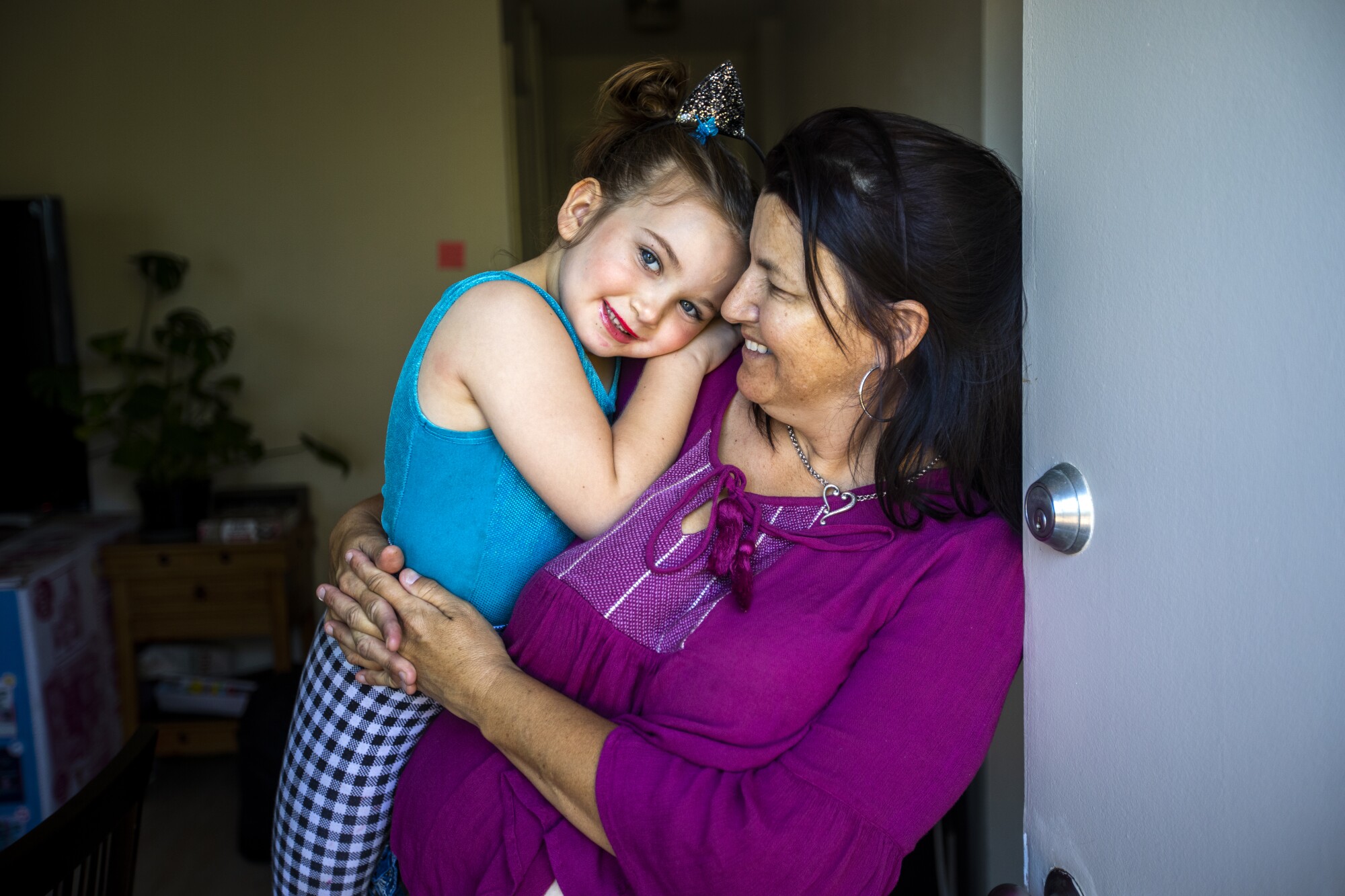 A woman holding a girl in a home