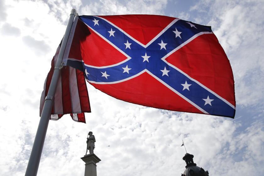 A protester waves a Confederate battle flag in front of the South Carolina statehouse, in Columbia, S.C. More than 50 years after South Carolina raised the flag to protest the civil rights movement, the rebel banner is scheduled to be removed Friday morning.