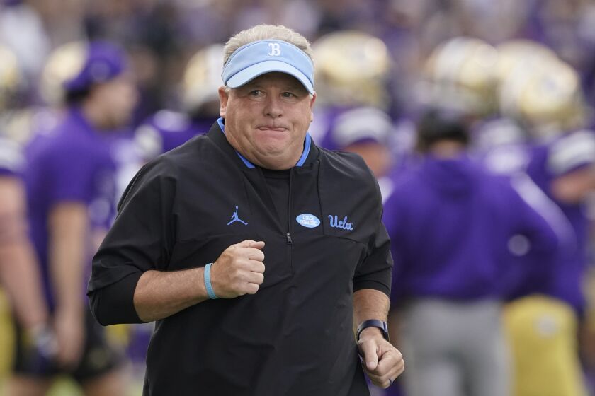 UCLA head coach Chip Kelly runs on the field before the team's NCAA college football game.