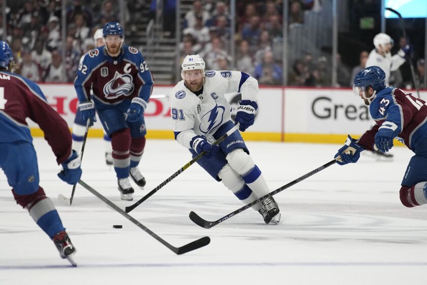 Tampa Bay Lightning center Steven Stamkos (91) controls the puck during the first period in Game 2 of the the team's NHL hockey Stanley Cup Final against the Colorado Avalanche, Saturday, June 18, 2022, in Denver. (AP Photo/John Locher)