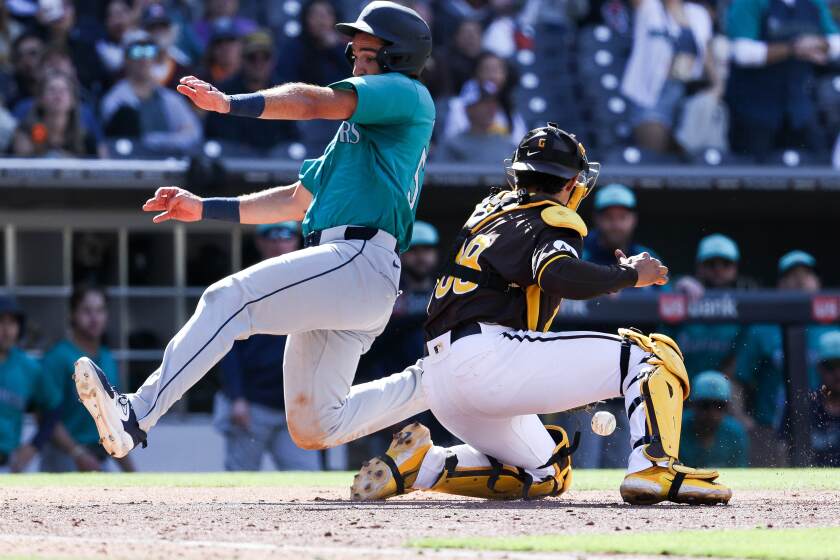 San Diego, CA - March 26: Seattle Mariners' Jake Anchia scores a run against San Diego Padres catcher Ethan Salas during the ninth inning of their exhibition game at Petco Park on Tuesday, March 26, 2024 in San Diego, CA. (Meg McLaughlin / The San Diego Union-Tribune)