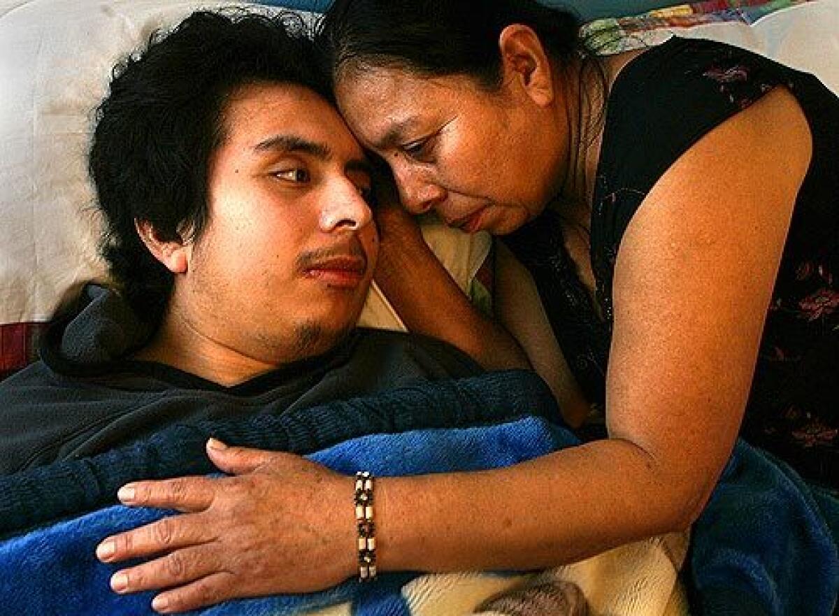 RECOVERING: Fernando Ramirez is comforted by his mother, Julia Suastegui, on his first day home after five months in a hospital. He was beaten allegedly by seven inmates.
