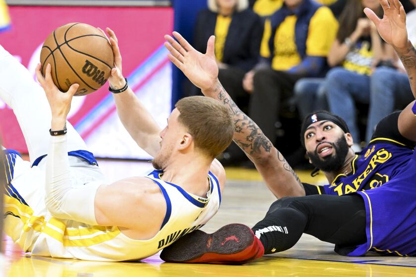 San Francisco, CA - MAY 04: Golden State Warriors guard Donte DiVincenzo, left, grabs onto a loose ball against Los Angeles Lakers forward Anthony Davis during the second half at Chase Center on Thursday May 4, 2023 in San Francisco, CA.(Wally Skalij / Los Angeles Times)