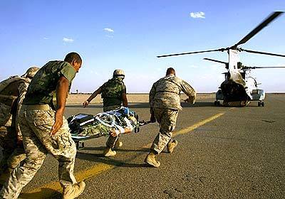 An injured Marine is rushed to a waiting helicopter following emergency surgery for injuries suffered in a mortar attack.