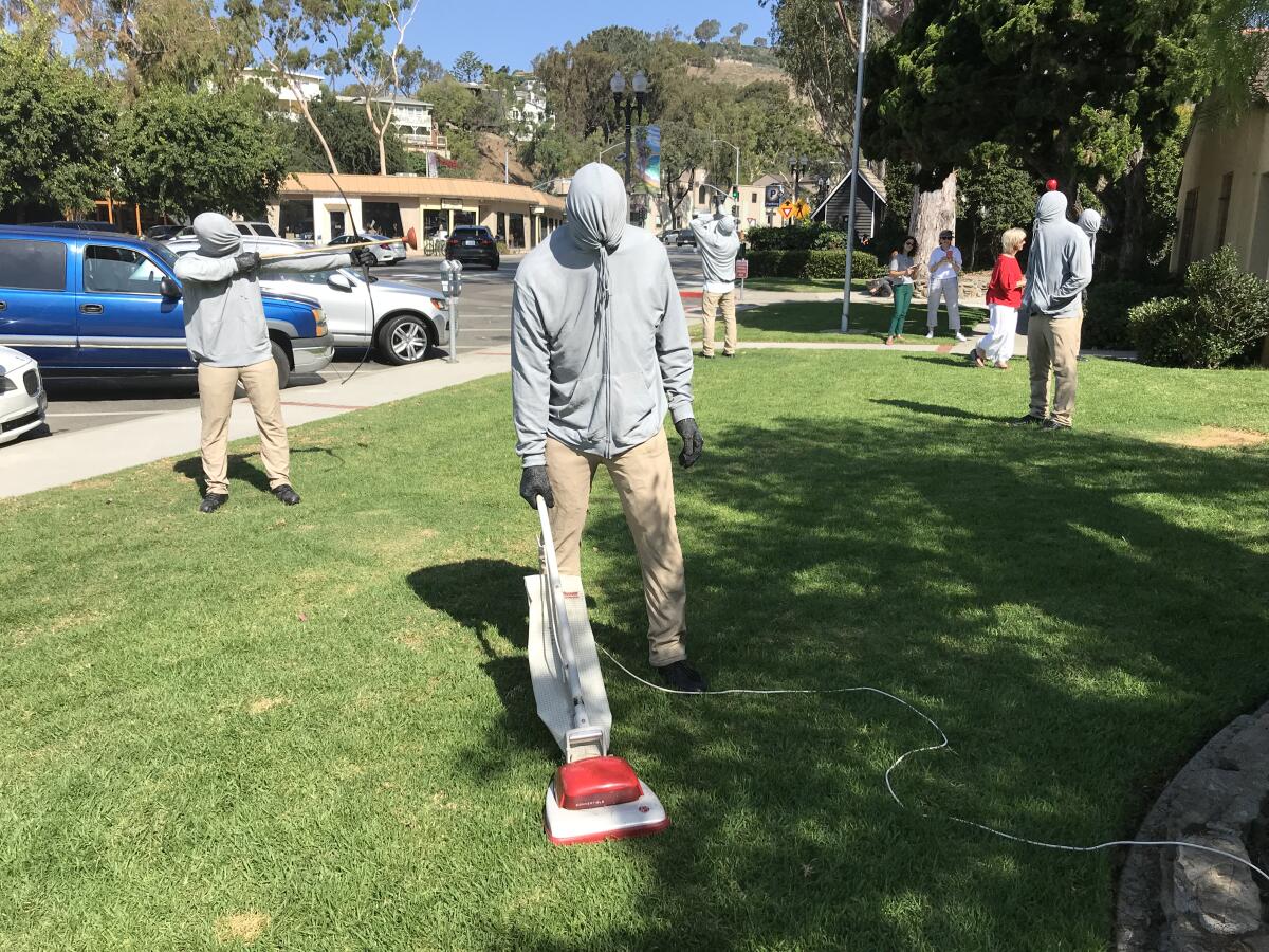 Realistic life-size characters, including this guy vacuuming the grass, are on display in front of Laguna Beach City Hall as part of a temporary installation by artist Mark Jenkins.