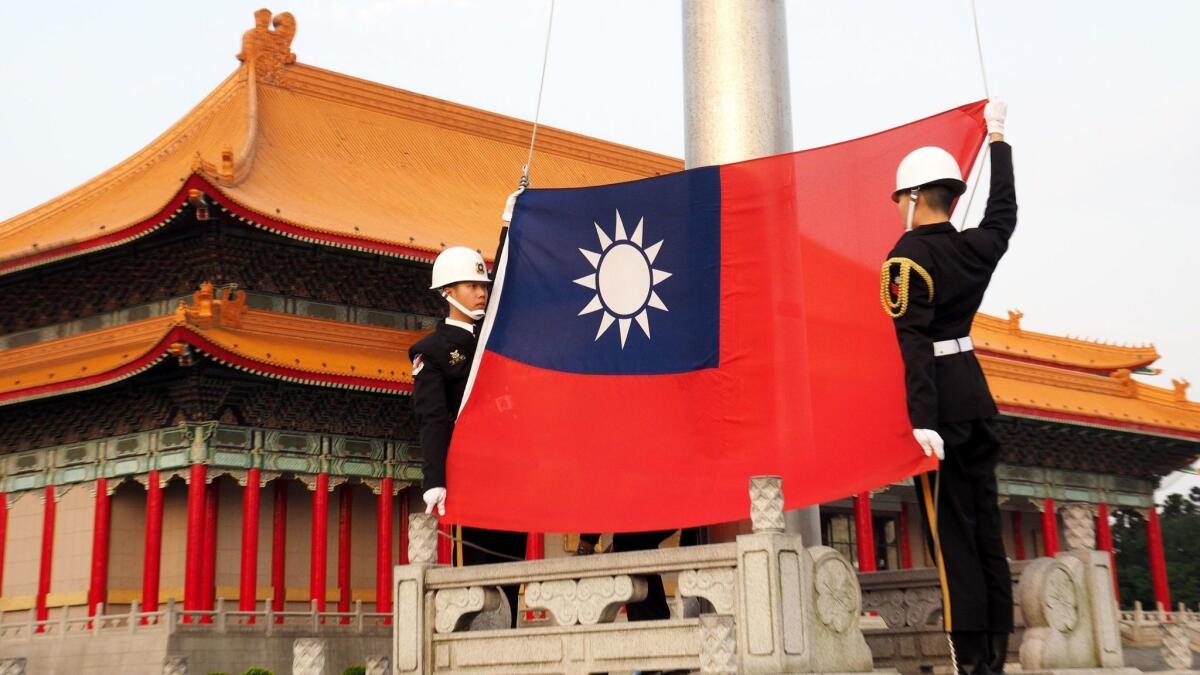 Soldiers hoist Taiwan's national flag at Liberty Square in Taipei, the capital, on March 25, 2018.