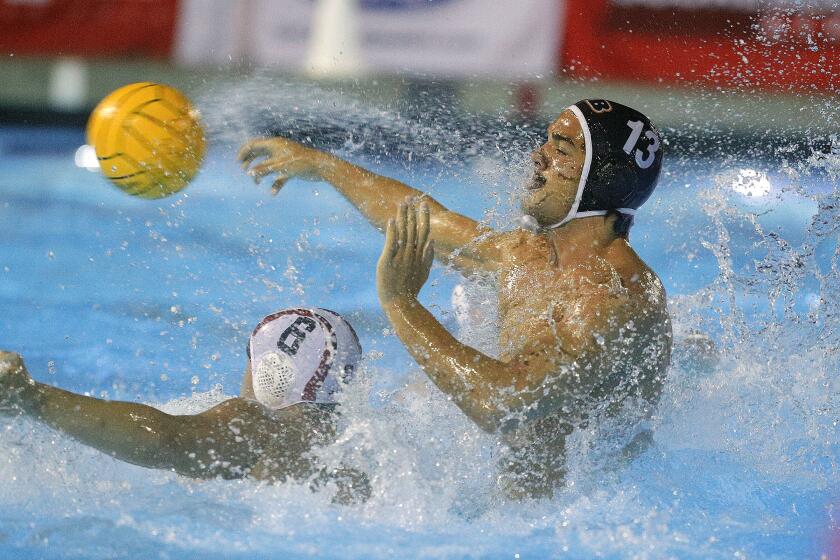Huntington Beach's Cooper Haddad takes a hard shot against Harvard-Westlake's Cristian Pang in CIF Southern Section Division 1 semifinal water polo playoffs at the Woollett Aquatics Center in Irvine on Wednesday, November 13, 2019. Harvard-Westlake won the game 10-7.