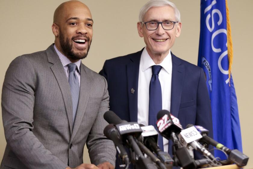 FILE - In this Jan. 3, 2019 file photo, Wisconsin Lt Gov-elect Mandela Barnes, left, and Democratic Gov-elect Tony Evers address the media in Madison, Wis. A new report shows that Wisconsin's Democratic Lt. Gov. Barnes has far more security than his Republican predecessor. The online publication WisPolitics.com reported Monday, May 13, 2019, that the State Patrol's Dignitary Protection Unit spent nine times as many hours protecting Barnes over a two-month period as it did his predecessor, Rebecca Kleefisch, in all of 2018. Barnes is the state's first African American lieutenant governor.(Steve Apps/Wisconsin State Journal via AP, File)