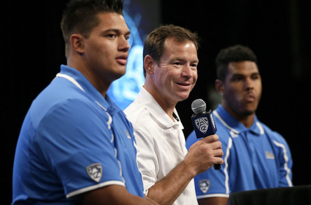UCLA Coach Jim Mora is flanked by offensive lineman Xavier Su'a-Filo, left, and linebacker Anthony Barr during a media session this summer.