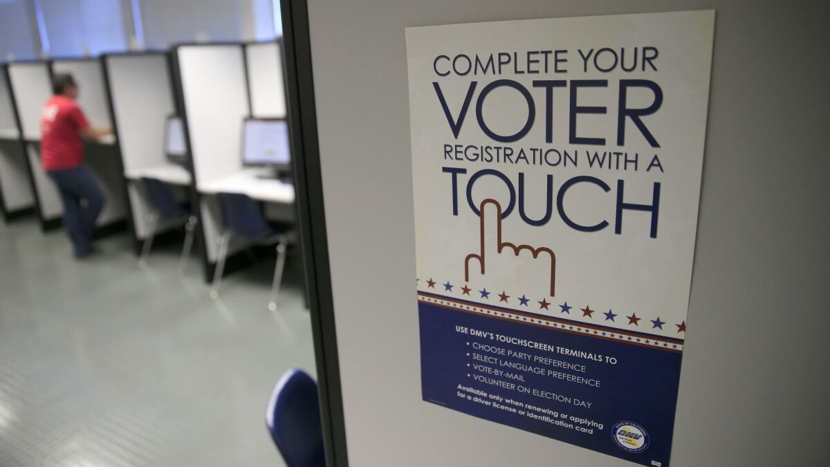 A sign advertises a touchscreen machine, a new process for voter registration at the Department of Motor Vehicles in Santa Ana.