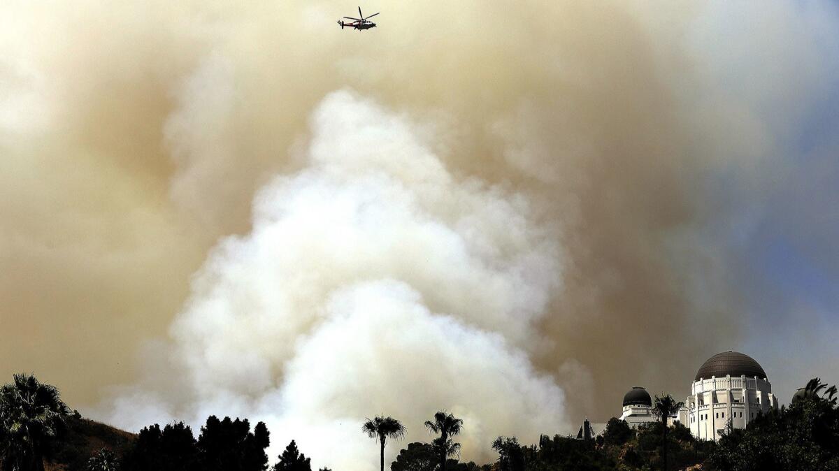 Smoke billows from a brush fire in Griffith Park near Griffith Observatory.